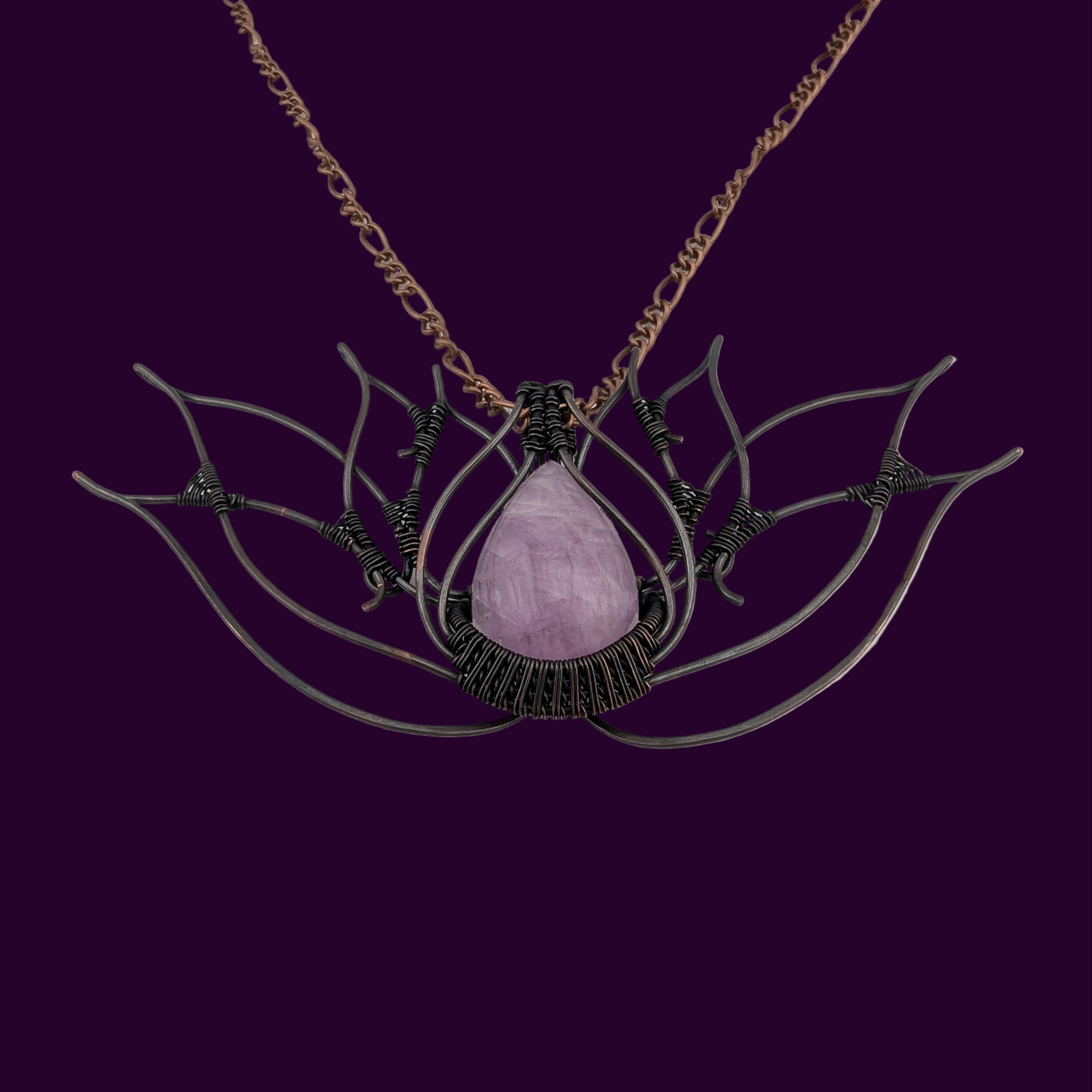 Necklace with a pink stone and intricate metalwork in the shape of a lotus